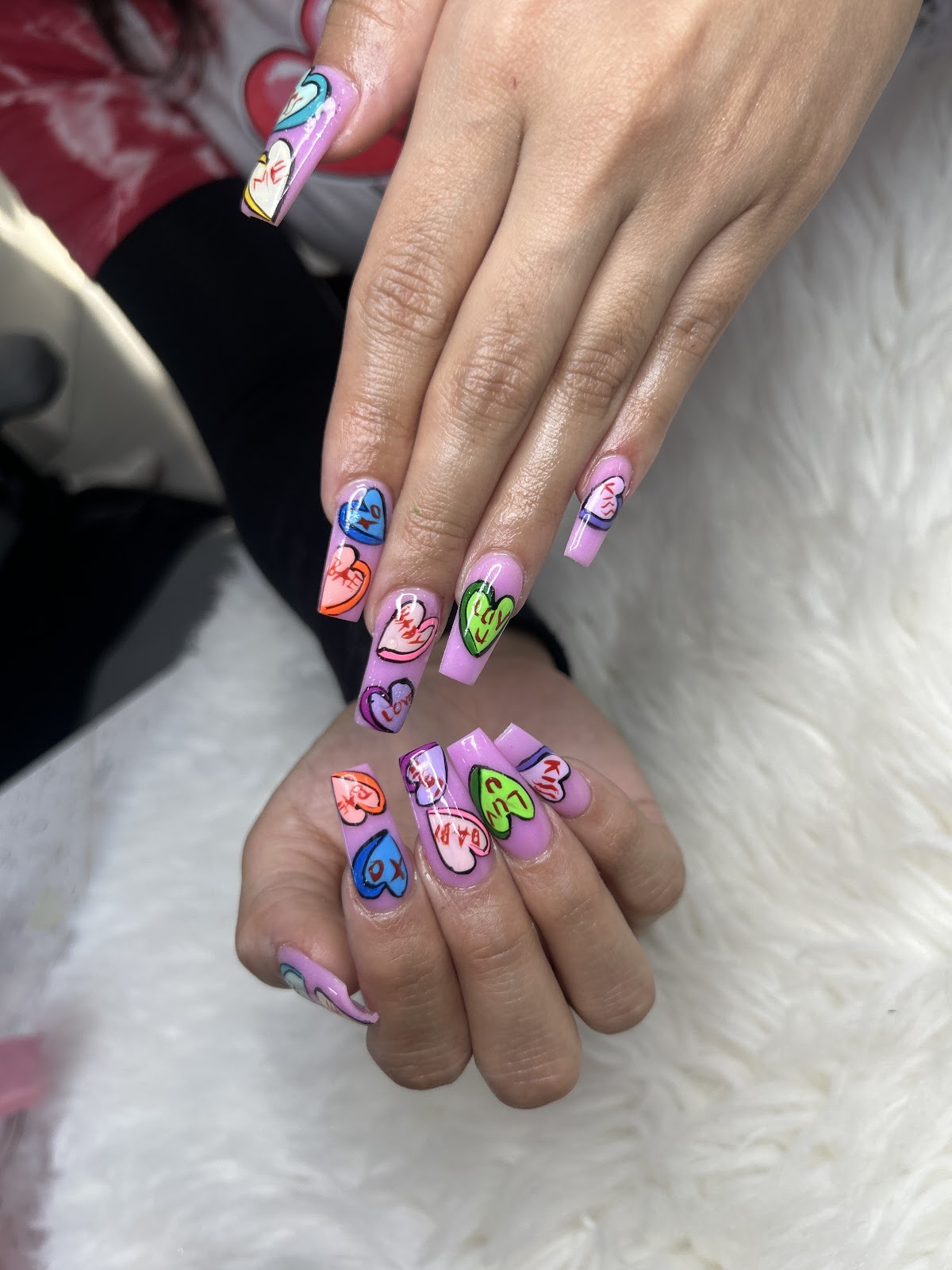Colorful conversation-heart Valentine's nail art on long square nails